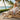 Breeze barefoot sneaker in cream mesh knit, worn seated on a beachside lounger at sunset