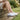 Wave barefoot sneaker in white, worn sitting on a stone step in a garden