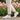 Cascade barefoot sneaker in white with pink, worn while walking past pink tulips