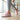 Cascade barefoot sneaker in pink with teal, worn in a barre studio, side view