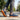 Grove barefoot sneaker for men in navy with gum sole, worn walking a park path