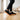 Grove barefoot sneaker for men in black with gum sole, side view on a wood floor
