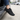 Terra barefoot trainer in black, worn stepping out of a car, side view