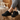 Haven barefoot lace up shoe in black worn with feet up on a wooden stool