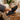 Grove barefoot sneaker in black, worn resting feet on a wooden table in a cozy room