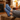 Stride barefoot sneaker for men in blue knit with brown sole, feet up by a fireplace