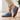 Stride barefoot sneaker in denim blue knit with gum sole, side view worn on a wood floor