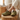 Flow barefoot slip on sneaker in olive green, worn resting on a wood stump indoors, side view