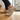 Meridian cushioned barefoot sneaker in sand worn stepping up wooden stairs