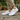 Meridian cushioned barefoot sneaker in white worn on a stone path, side view