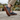 Sage barefoot sneaker in grey plaid worn on a stone path, side view