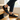 Loafers barefoot slip on shoe in black worn on wooden stairs, three quarter view