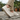 Breeze barefoot sneaker in cream worn stepping on a stone, side view