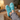 Wave barefoot sneaker in teal, worn with feet up on a table in a cozy living room