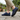 Wave barefoot sneaker in navy blue, worn walking on stone pavers by a garden