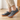Wave barefoot sneaker in grey with a gum sole, worn standing indoors on a wood floor