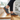 Wave barefoot sneaker in grey with a gum sole, worn stepping up wooden stairs