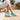 Wave barefoot sneaker in teal, worn sitting on a sunny tiled patio