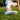 Terra barefoot trainer in white, worn kneeling on grass in a park, side view showing the sole tread
