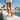 Pulse barefoot sneaker in white with gum sole, worn walking a seaside promenade, rear view showing the sole