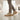 Pulse barefoot sneaker in sand beige with gum sole, worn walking in an art gallery, side view