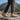 Trailblazer barefoot hiking shoe for men in light grey with orange, worn walking on a rocky ridge, side view