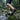 Trailblazer barefoot hiking shoe for men in black with lime green, worn crossing a mossy stream, side view