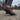 Trailblazer barefoot hiking shoe for men in dark grey with orange, worn walking on a gravel path, side view with lug sole