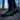Trailblazer barefoot hiking shoe for men in black with yellow, worn standing in a bare winter forest, side view