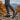 Trailblazer barefoot hiking shoe for men in dark grey with orange, worn walking on rocky autumn terrain, side view