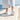 Flow barefoot slip on sneaker in white, worn walking on a seaside promenade, rear view showing the sole