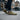 Flow barefoot slip on sneaker for men in olive green, worn walking a city street, three quarter view