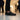 Flow barefoot slip on sneaker for men in black, worn standing in an art gallery, side view