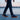 Grove barefoot sneaker for men in navy with orange sole, worn walking a waterfront
