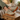 Summit barefoot hiking shoe in khaki taupe with orange sole, worn feet up on a wood table