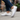 Terra barefoot trainer for men in white, worn on a city sidewalk, one shoe lifted showing the flexible sole tread