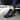 Trailblazer barefoot hiking shoe in black with lime green, single shoe worn stepping out of a car, side view