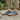 Anchor barefoot sneaker in charcoal grey worn on a stone path, front view