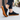 Anchor barefoot sneaker in black worn on a sidewalk, side view of the gum sole