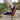 Grove barefoot sneaker in navy, worn walking on stone pavers by a garden wall
