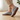 Stride barefoot sneaker in gray heather knit with gum sole, side view worn on a wood floor