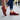 Stride barefoot sneaker in red knit with gum sole, worn standing on a city sidewalk