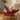 Stride barefoot sneaker in dark red knit with brown sole, worn with feet up on a wood stump