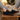Stride barefoot sneaker in black knit with gum sole, worn with feet up on a wood stump