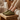 Flow barefoot slip on sneaker in olive green, worn on a wooden stool indoors, side view