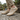 Meridian cushioned barefoot sneaker in sand worn on a stone path, front view