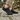 Meridian cushioned barefoot sneaker in black worn on a stone path, three quarter view