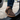 Sage barefoot sneaker in brown worn stepping out of a car, side view
