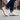 Pulse barefoot sneaker for men in white with gum sole, worn mid stride on a city sidewalk, side view