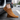 Ease barefoot slip on shoe in tan brown, worn side view beside a car on asphalt